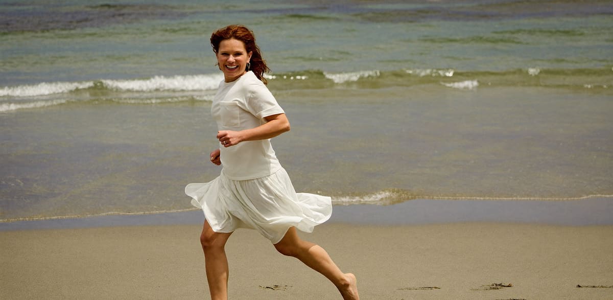 A woman running along firm sand at low tide