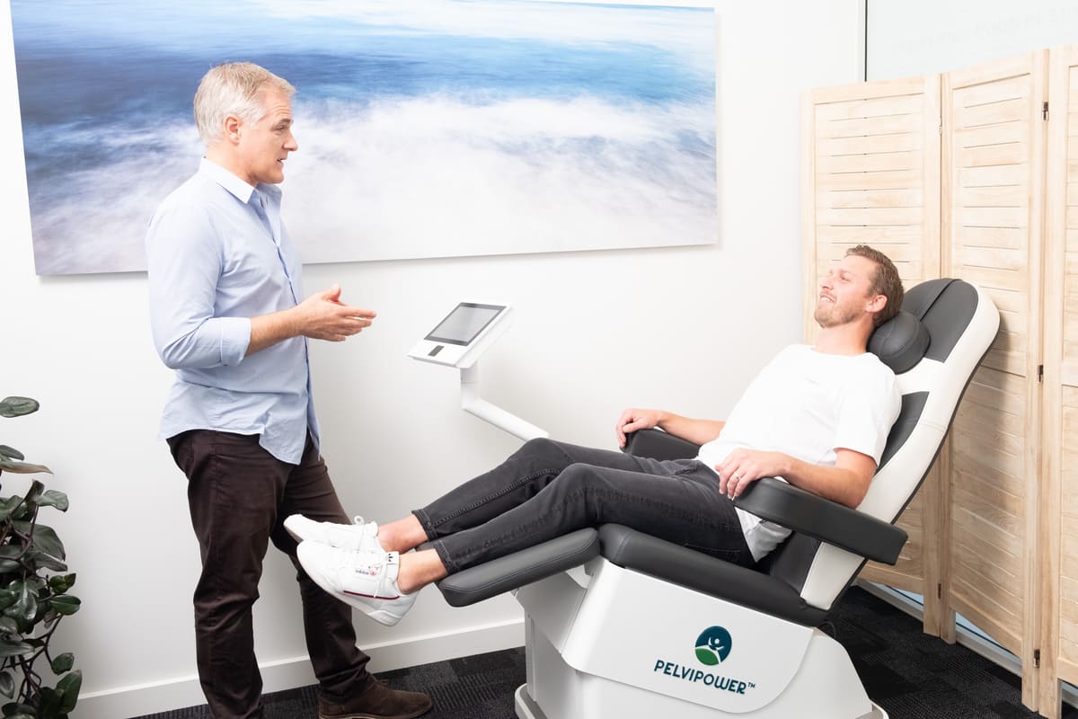A PelviPower chair session at the CoreGood clinic, seated and fully clothed, with Nathan Scott alongside
