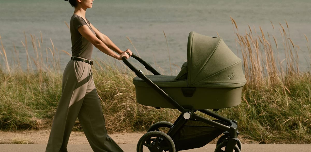 A woman walking a coastal path with a pram