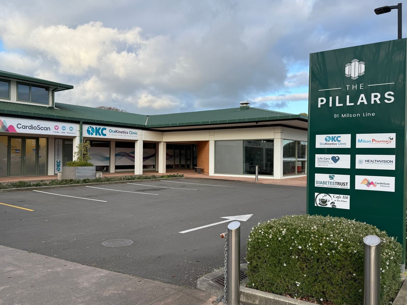 The Pillars at 91 Milson Line, Palmerston North. The tenant board lists OraKinetics Clinic and Milson Pharmacy, and the OraKinetics entrance is under the green roof behind it.